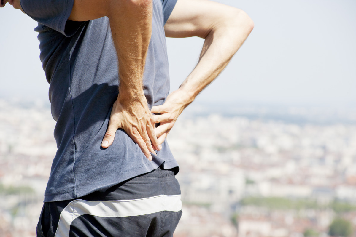 A male person, having severe lower-back pain.
